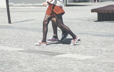 Low section of women walking on street in stockings