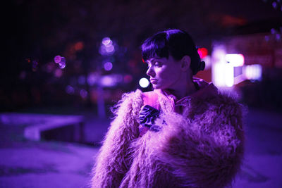 Young woman looking away at night during winter