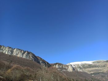 Scenic view of mountains against clear blue sky