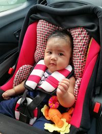 Portrait of cute baby girl sitting on seat