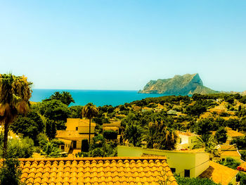 Scenic view of sea and buildings against clear sky