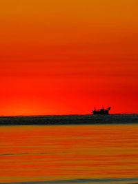 Scenic view of sea against orange sky