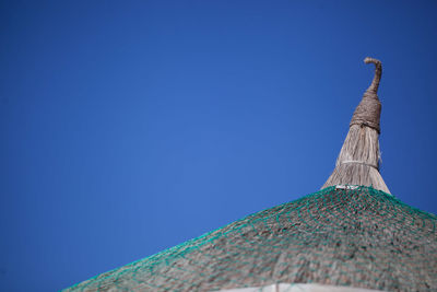 Thatched roof against clear blue sky