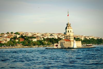 Maiden tower on sea against sky