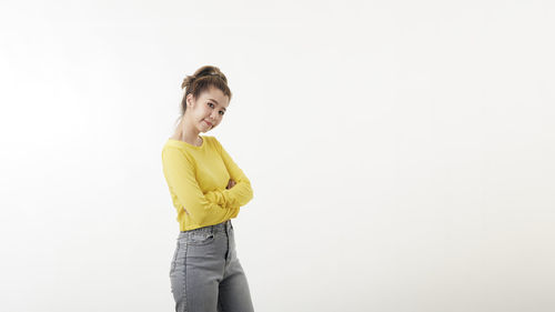 Portrait of smiling young woman against white background
