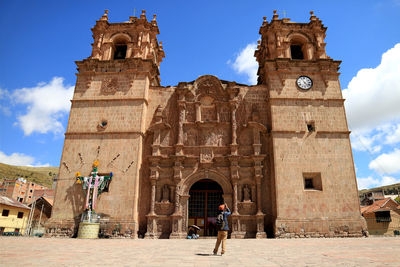 People outside historic building against sky