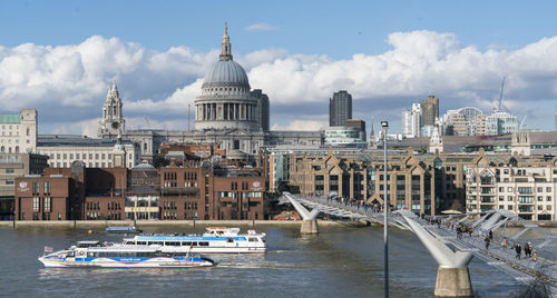 Boats in canal by buildings in city