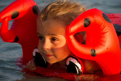 Cute girl swimming with inflatable ring in sea