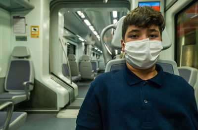 View of a boy wearing a mask inside a subway car in malaga during pandemic..