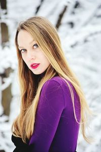 Portrait of young woman with blond hair standing outdoors during winter