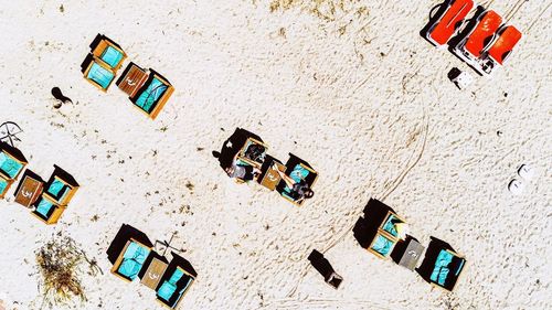 High angle view of friends sitting on chairs at beach