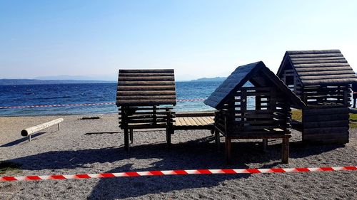 Deck chairs on beach against clear sky