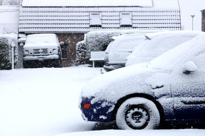 Snow covered car in city