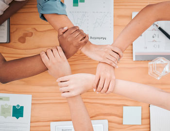 Midsection of business people stacking hands