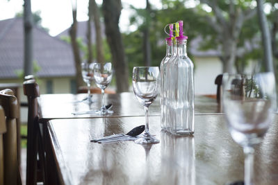 Wineglasses and bottles on table outdoors