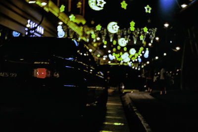 Cars on illuminated street in city at night