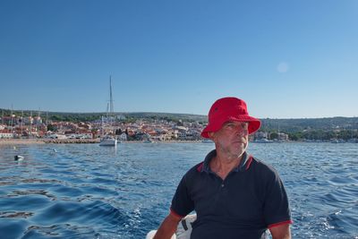 Man on sea against blue sky