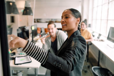 Young businesswoman addressing colleagues at office meeting