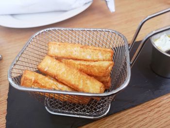 High angle view of halloumi fries in basket on table