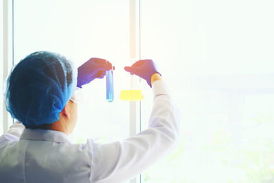 Rear view of scientist holding test tube at laboratory