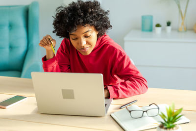 Young woman using laptop at table