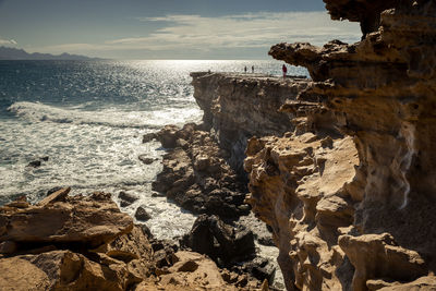 Rock formation on beach against sky