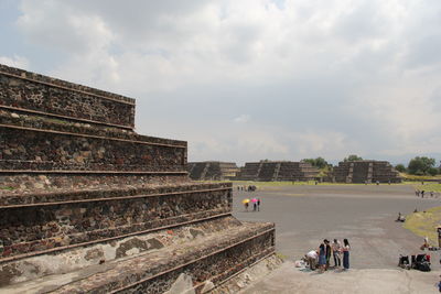 Group of people at temple against sky