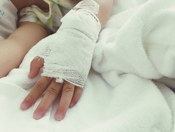 Close-up of baby lying on bed in hospital