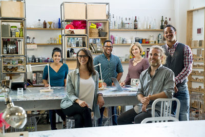 Portrait of happy business people at conference table in office