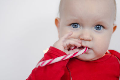 Christmas portrait of a beautiful little child holding a candy cane