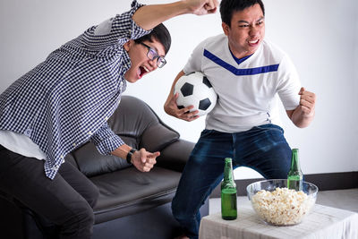 Friends dancing while watching sports on tv at home