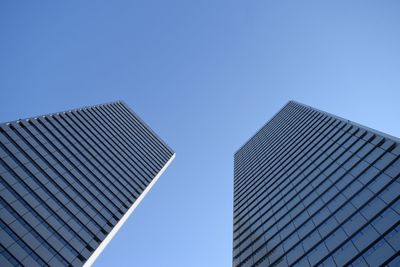 Tilted view of glass buildings against clear sky
