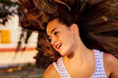 Smiling teenage girl tossing hair