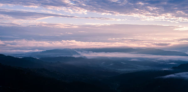 Aerial view of majestic mountains against sky during sunset