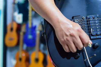 Cropped image of musician playing guitar at store