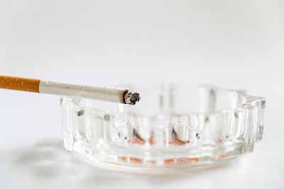 Close-up of cigarette glasses against white background