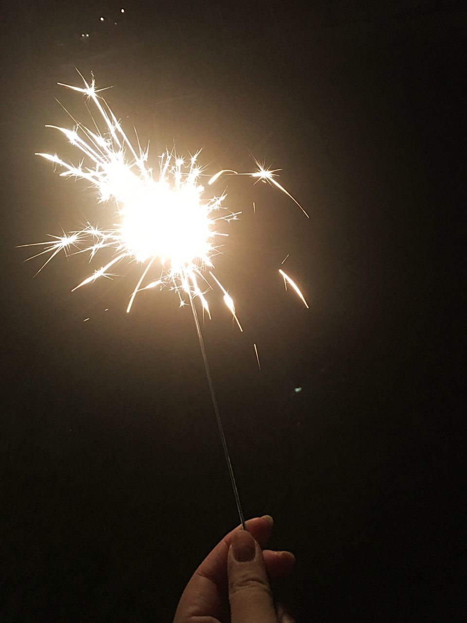 motion, human hand, celebration, long exposure, sparks, holding, exploding, one person, sparkler, blurred motion, firework - man made object, firework display, real people, human body part, outdoors, night, firework, sky, people