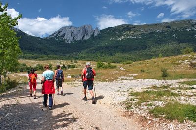 People walking on mountain against sky