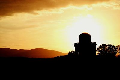 Silhouette tower against sky during sunset