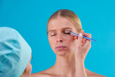 Portrait of woman against blue background