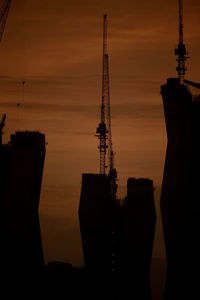 Silhouette of communications tower against sky