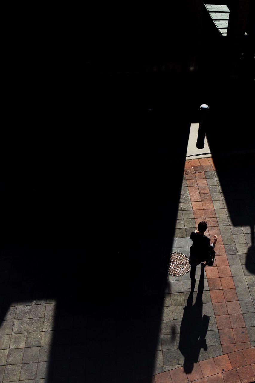 lifestyles, full length, walking, shadow, silhouette, night, men, leisure activity, architecture, built structure, street, standing, building exterior, rear view, person, sunlight, outdoors, wall - building feature