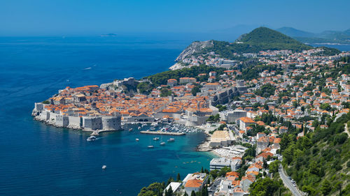 High angle view of townscape by sea against sky