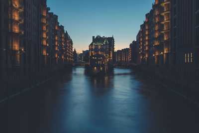 Reflection of buildings in water at sunset