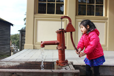 Cute girl using hand pump