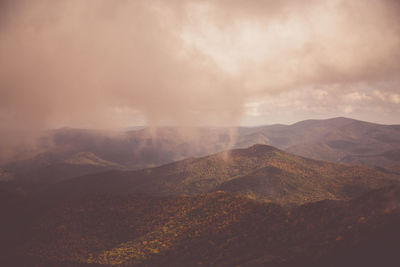 Scenic view of mountains against cloudy sky