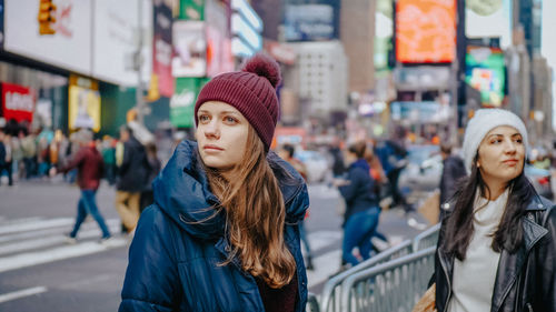 Portrait of young woman in city street during winter