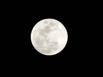 Low angle view of full moon against clear sky at night