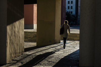 Rear view of man walking in building