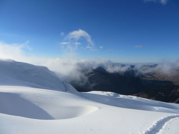 Scenic view of mountain range against cloudy sky